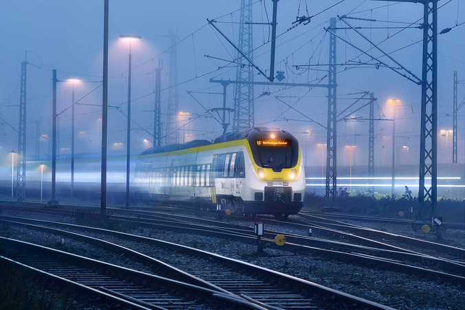 Il treno giallo e bianco di SWEG viaggia di notte.