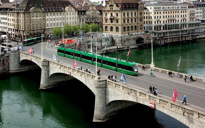 Un tram verde su un ponte sul fiume a Basilea