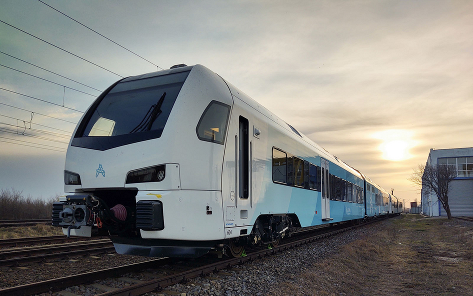 Ferrovia bianco-bluastra di Stadler davanti a un tramonto