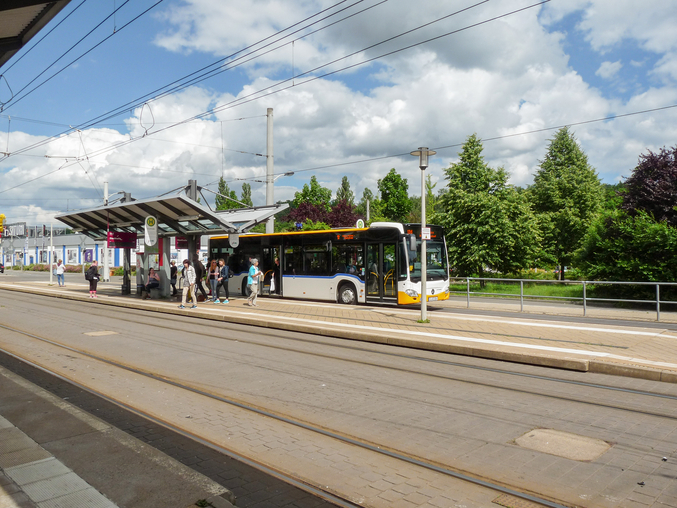 Bus at a bus stop with passengers getting on and off the bus