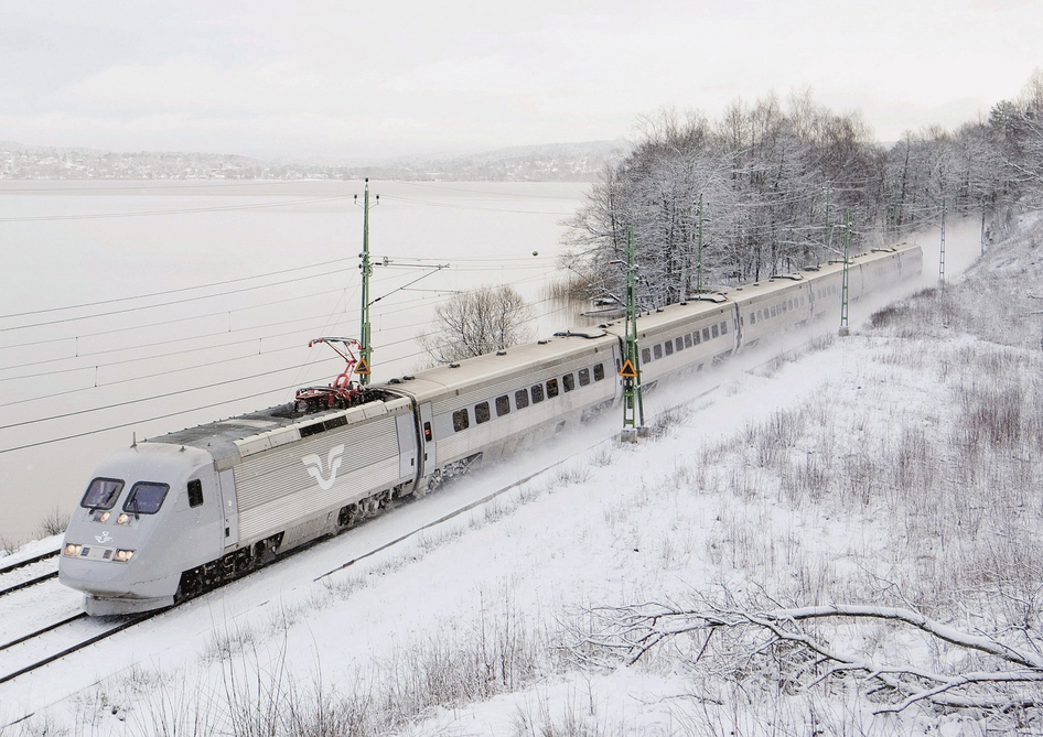 Treno SJ bianco nella neve davanti a un lago ghiacciato