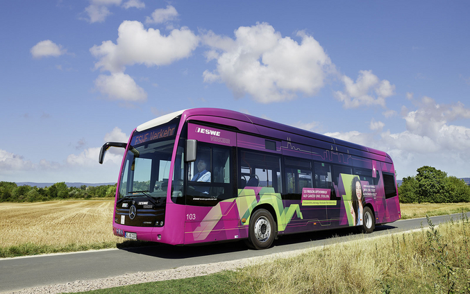 Un autobus ESWE viola attraversa una zona rurale.