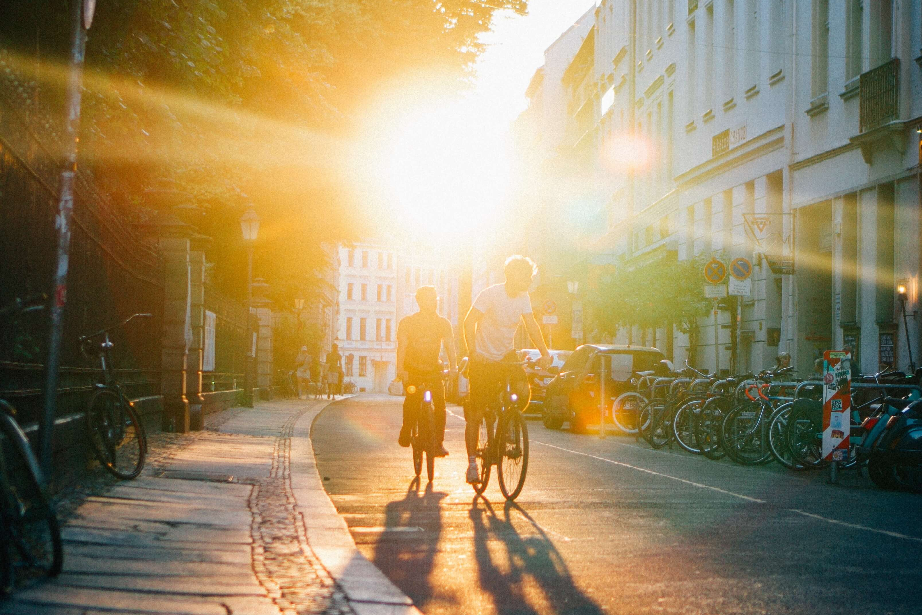 Due ciclisti percorrono la strada al tramonto