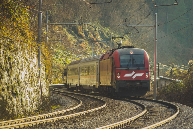 La ferrovia rossa della Nuova Zelanda di fronte a montagne ricoperte di vegetazione