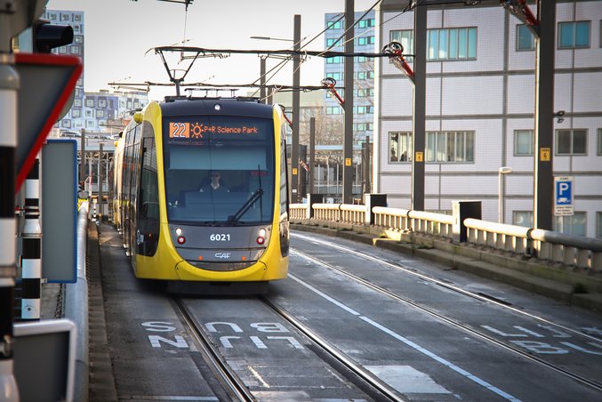 Un tram giallo e nero della provincia di Utrecht è fermo in una stazione.