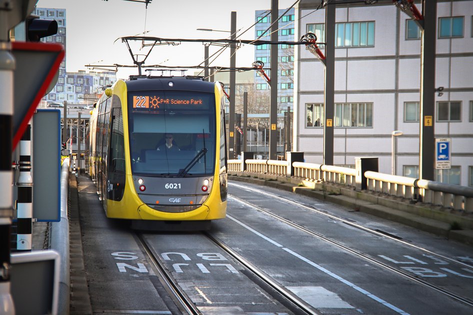 Un tram giallo e nero della provincia di Utrecht è fermo in una stazione.