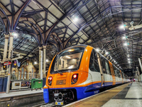 Ein orangener Zug von Arriva Rail London steht in einem Londoner Bahnhof.