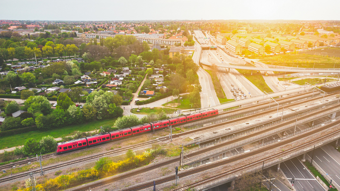 Antenna di un treno pendolare DSB rosso che attraversa Copenaghen con il sole al tramonto.