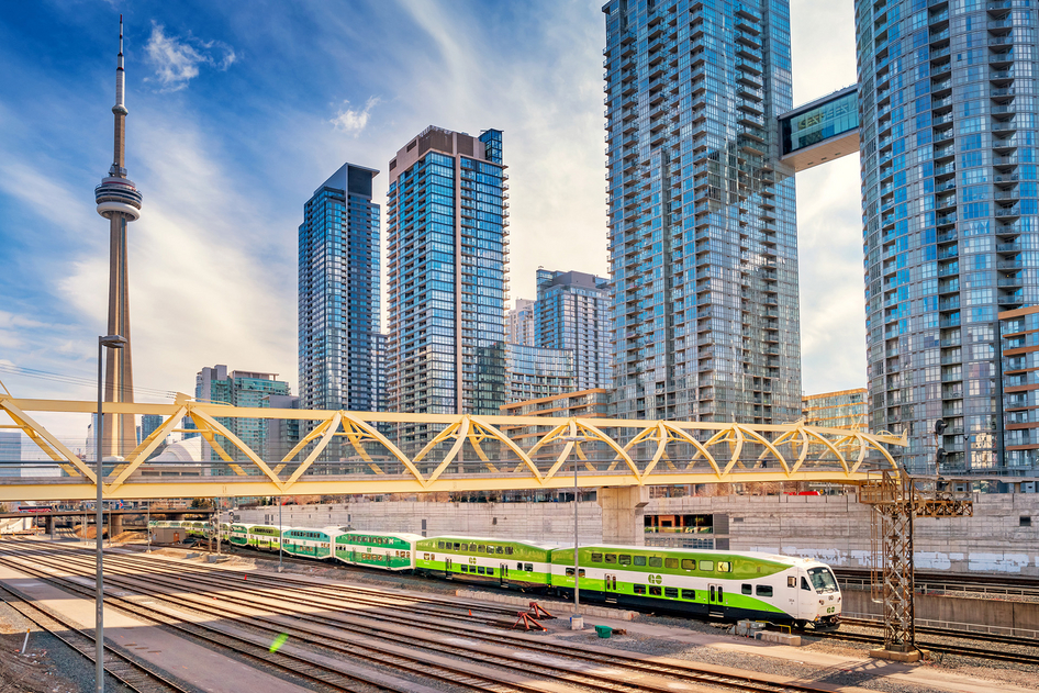 Il treno regionale verde e bianco di GO Transit davanti ai grattacieli di Toronto