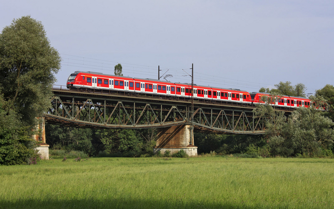 Il treno rosso della S-Bahn di Stoccarda attraversa un ponte in una regione rurale