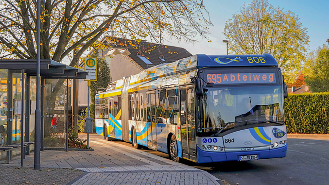 Un autobus blu della SWS alla fermata di Solingen al tramonto.